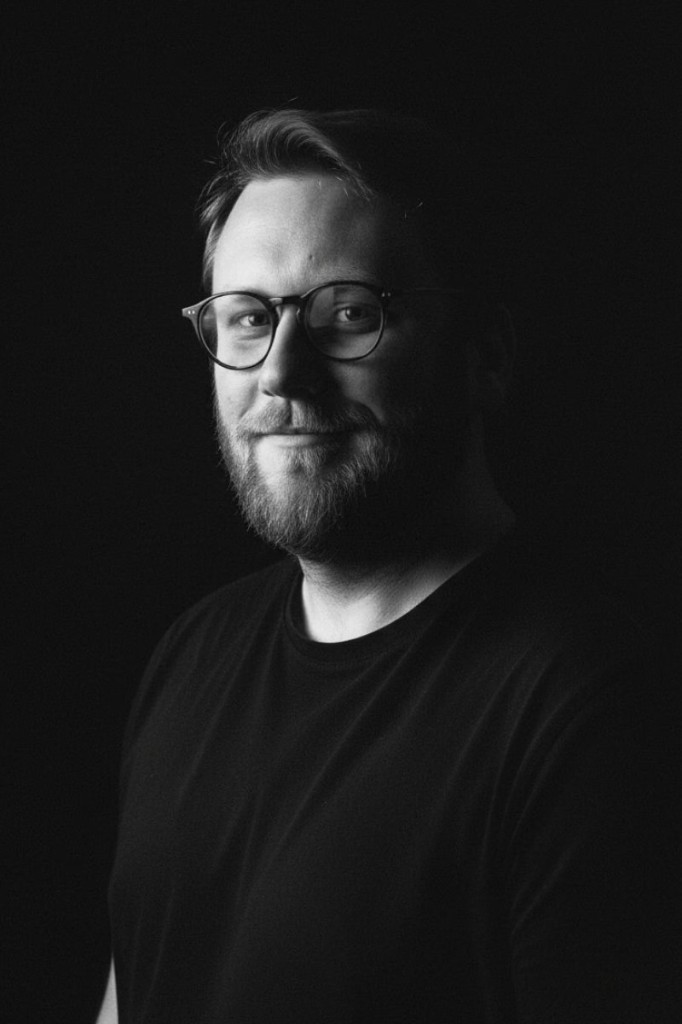 Portrait de Loïc Vanderschooten en noir et blanc, fond noir